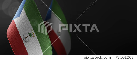 Small national flags of the Equatorial Guinea on a dark background 75101205