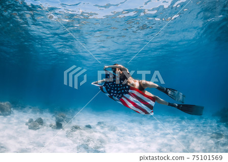 Freediver woman swim over sandy sea with United States flag. Freediver woman swim over sandy sea with United States flag. 75101569