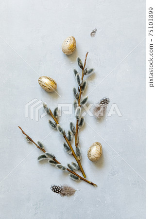 Happy Easter concept. Preparation for holiday. Golden decorated easter eggs willow feather on concrete stone grey background. Simple minimalism flat lay top view copy space. 75101899