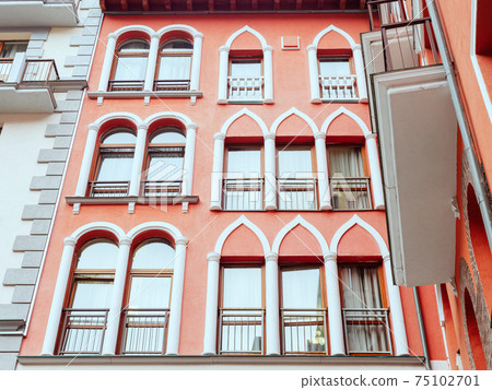 Rectangular windows with arched and domed decor on a coral wall Rectangular windows with arched and domed decor on a coral wall 75102701