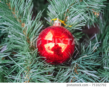 Red glossy ball in green spruce branches. Close-up photo Red glossy ball in green spruce branches. Close-up photo 75102702