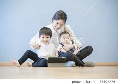 Parents and children enjoying online communication using a tablet PC 75102876