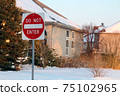 Do not enter sign on the residential building background, entry is prohibited. Winter, snowfall in North American suburban. Icey, snowy street 75102965