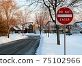 Do not enter sign on the residential building background, entry is prohibited. Winter, snowfall in North American suburban. Icey, snowy street 75102966