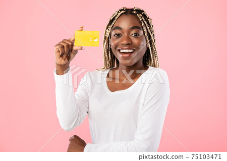 Black woman holding credit card and smiling 75103471