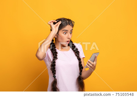 Excited indian woman using cellphone, celebrating online win Excited indian woman using cellphone, celebrating online win 75103548