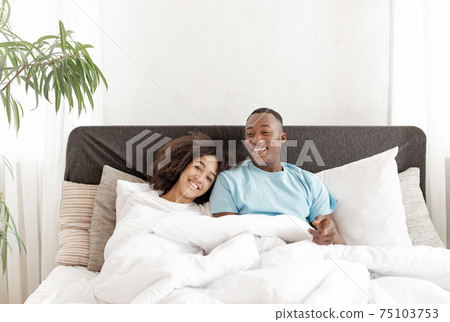 Weekend in bed, waking, good morning in comfortable interior at new home after repair Weekend in bed, waking, good morning in comfortable interior at new home after repair 75103753