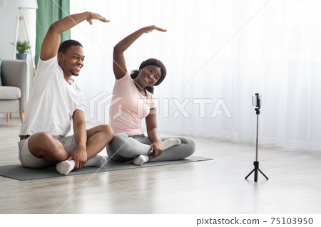 Cheerful african american family practicing yoga at home Cheerful african american family practicing yoga at home 75103950