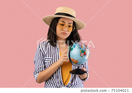 Sad Asian Woman Holding Globe, Pointing At Map Sad Asian Woman Holding Globe, Pointing At Map 75104021