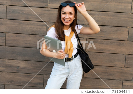 Photo of beautiful fascinating charming smiling young brunette girl wearing white t-shirt light blue Photo of beautiful fascinating charming smiling young brunette girl wearing white t-shirt light blue 75104424