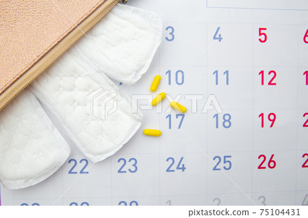 Pink beautician with daily cotton sanitary pads and hormonal contraceptive on calendar. Travel cosmetic bag. Hygiene protection for woman critical days 75104431
