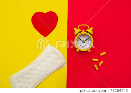 Sanitary pads, alarm clock and hormonal contraceptive pills on colorful background. Female's menstrual cycle concept. Pain relievers for menstrual pain Sanitary pads, alarm clock and hormonal contraceptive pills on colorful background. Female's menstrual cycle concept. Pain relievers for menstrual pain 75104443