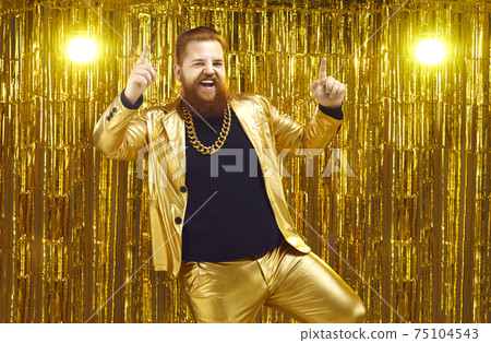Rich chubby man in a golden suit dances at a party or disco on a bright shiny background. 75104543