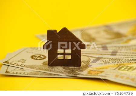 Buying house concept. Legal mortgage. Hose with money on the yellow table. Buying house concept. Legal mortgage. Hose with money on the yellow table. 75104729