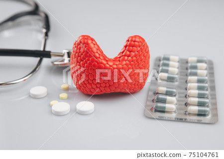 Thyroid with stethoscope and medicines on the grey table. 75104761