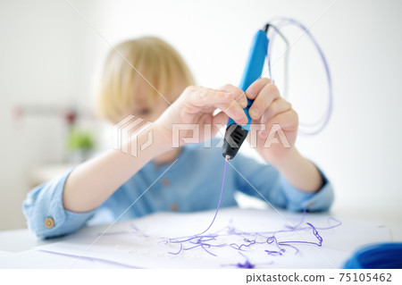 Little boy learning make model with 3d printing pen 75105462