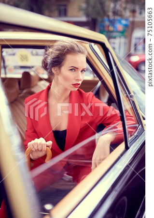Beautiful young woman in retro car 75105663