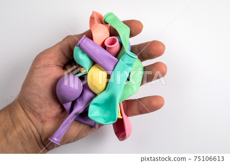 Colored balloons in a man's hand on a white background Colored balloons in a man's hand on a white background 75106613