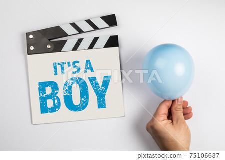 It's a boy. Birthday and sonographic examination concept. Movie clapper and a blue balloon on a It's a boy. Birthday and sonographic examination concept. Movie clapper and a blue balloon on a 75106687