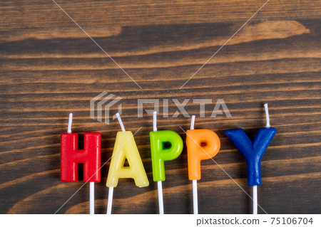 Happy. Coloured anniversary candles on a wooden background 75106704