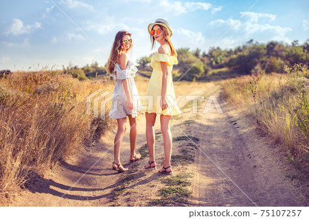 two pretty girlfriends in summer dresses 75107257