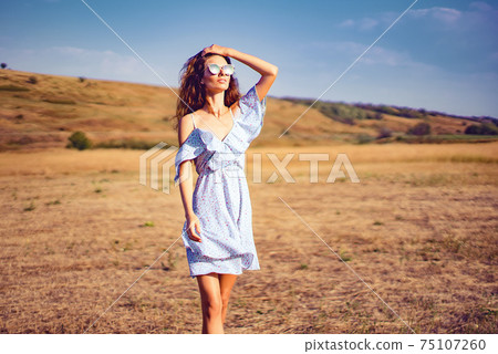 beautiful young woman outdoor on the hill on a summer day 75107260