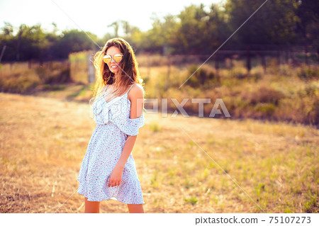 beautiful young woman outdoor on the hill on a summer day beautiful young woman outdoor on the hill on a summer day 75107273