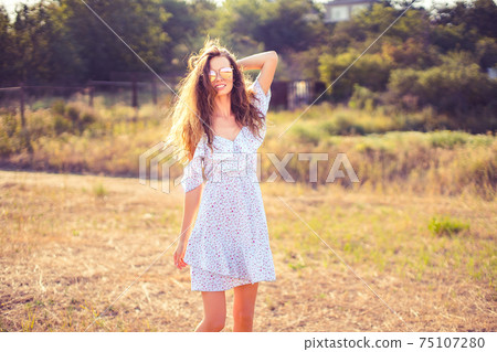 beautiful young woman outdoor on the hill on a summer day beautiful young woman outdoor on the hill on a summer day 75107280
