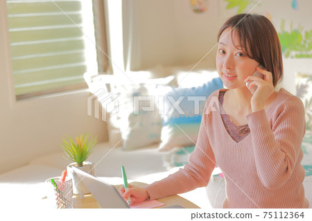 A woman who smiles and takes notes while calling _ diagonally 75112364