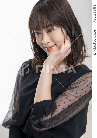 Woman in her thirties in a black dress Woman in her thirties in a black dress 75113981