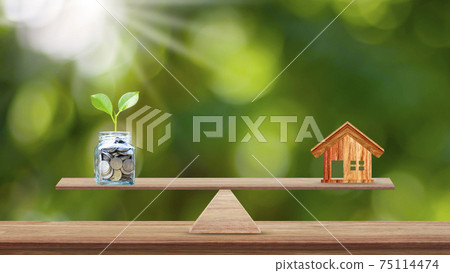House and Tree Planted in Bottles Saving Money Placed on Wood Scales in Parks, Savings Ideas for Buying a New Home or Real Estate and Business Investment Planning. 75114474