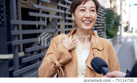 A woman undergoing a street interview A woman undergoing a street interview 75114726