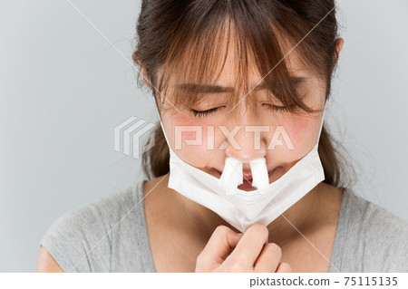 A woman who dislikes the smell of masks A woman who dislikes the smell of masks 75115135