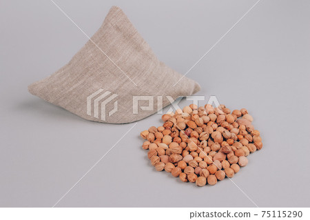 Cherry stone pillow, cherry pit filled pillow - natural heat or cool pack. Alternative medicine and therapy, pit sack for spa massage, chiropractic care and home health. Copy space and mockup Cherry stone pillow, cherry pit filled pillow - natural heat or cool pack. Alternative medicine and therapy, pit sack for spa massage, chiropractic care and home health. Copy space and mockup 75115290