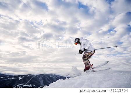 Male skier skiing downhill trough deep snow in mountains. Male skier skiing downhill trough deep snow in mountains. 75115794