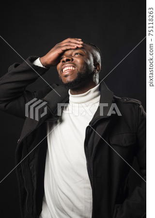 Black man laughing with his hand on his face. Black man laughing with his hand on his face. 75118263