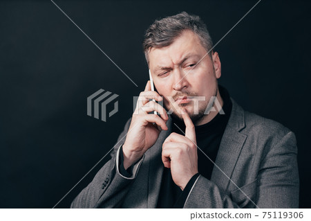 Thoughtful pensive man talking over the phone Thoughtful pensive man talking over the phone 75119306