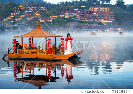 Asian woman wearing chinese traditional dress on a boat at Ban Rak Thai village, Mae hong son province. 75119554