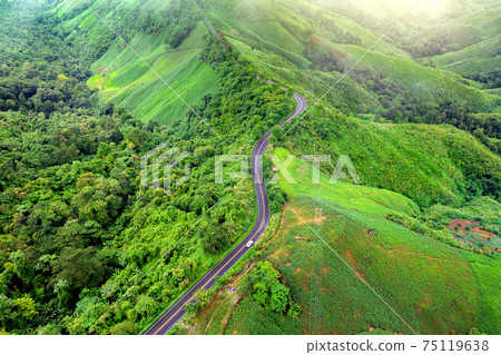 Aerial view of Beautiful sky road over top of mountains with green jungle in Nan province, Thailand. 75119638
