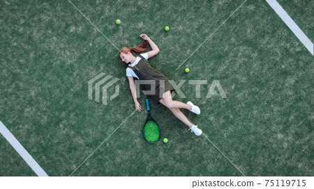 Beautiful girl lies on a tennis court Beautiful girl lies on a tennis court 75119715