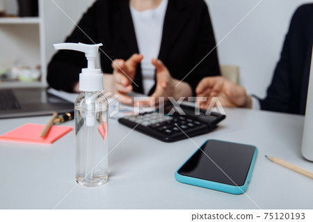 Close-up of workspace with antiseptic gel to disinfect hands in an office. Preventive measures during the period of epidemic and social exclusion 75120193