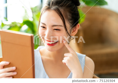 Women in their twenties looking at a mirror 75120304