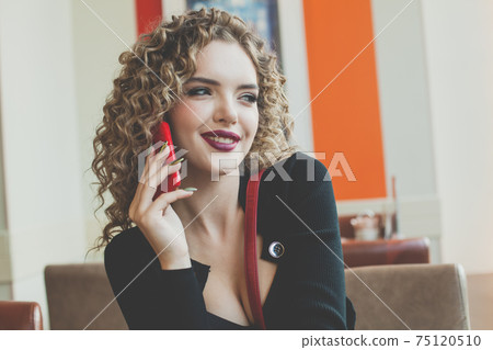 Beautiful happy young woman using smartphone in european city street cafe 75120510