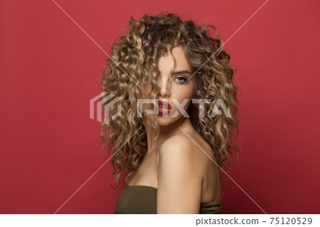 Perfect young woman model with curly hairstyle on red background 75120529