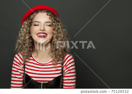 Portrait of a cheery woman dressed in striped t-shirt and red french style beret  75120532