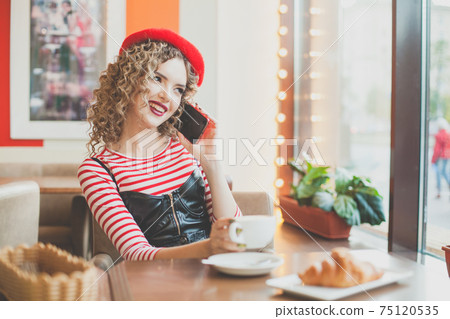 Happy smiling woman using smartphone in cafe 75120535
