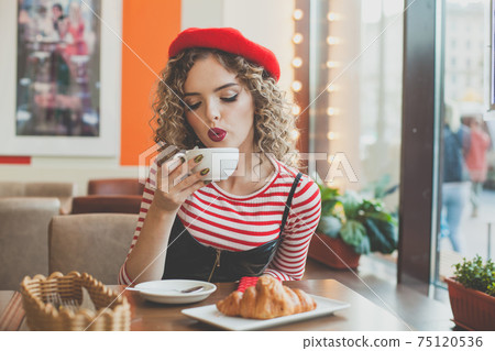 Attractive woman with coffee cup in city street cafe 75120536