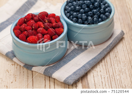 Bilberry and strawberry on table, organic food concept 75120544