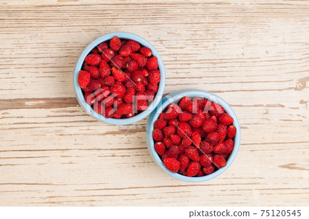 Red organic strawberry in blue bowls 75120545
