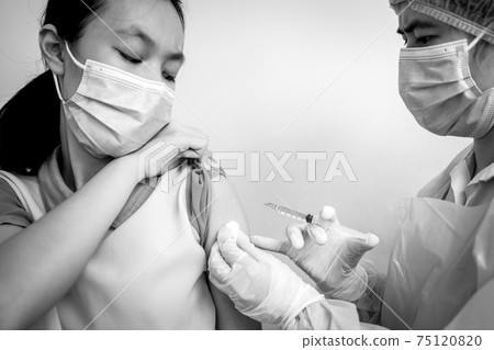 Doctor injecting Coronavirus vaccine with syringe injection into shoulder of child girl,dangers of COVID-19 vaccine,side effects of dangerous drugs,vaccine allergy,medicine,vaccination,medical concept 75120820